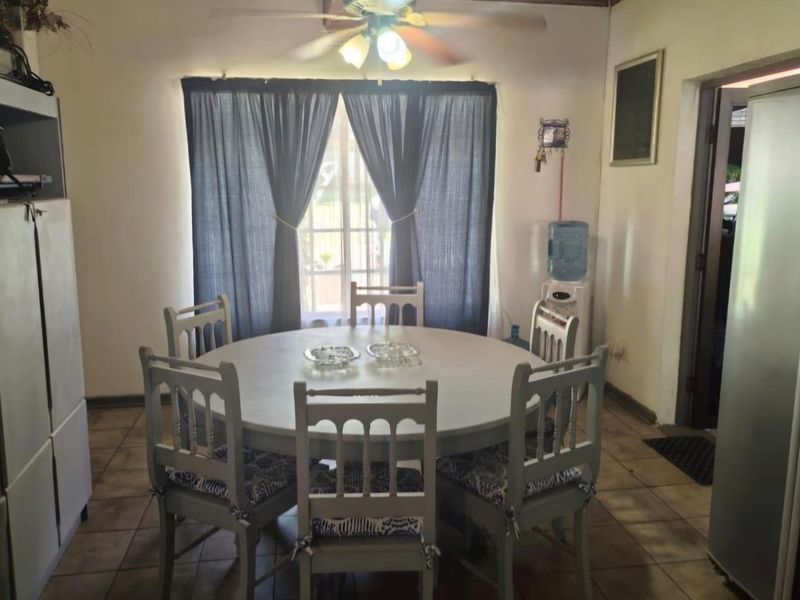 A functional dining room featuring tiled flooring and a central ceiling fan, providing a practical space for family meals.