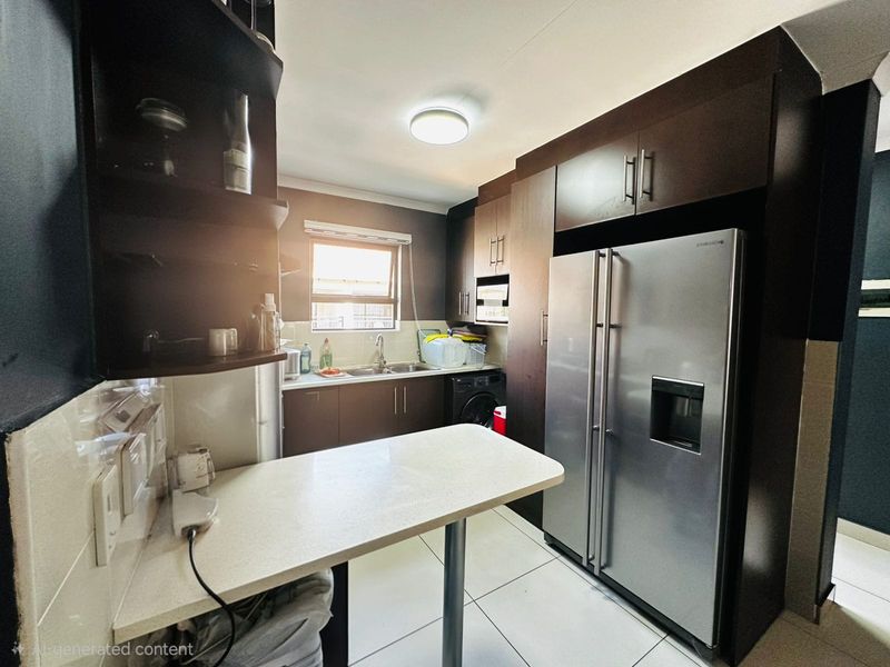 A functional kitchen featuring dark wood cabinetry, a breakfast counter, tiled flooring, and space for a large refrigerator.