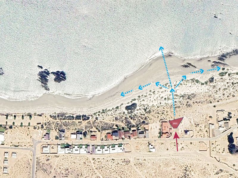 Aerial view of the residential property highlighting its prime beachfront location and proximity to the coastline.