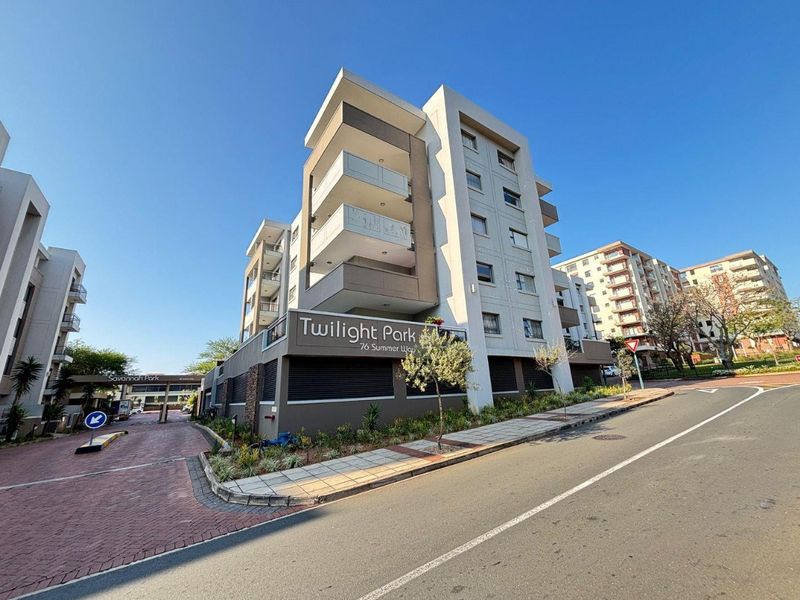 Exterior view of the Twilight Park apartment complex, featuring modern facade design, private balconies, and secure gated entrance access from the street.