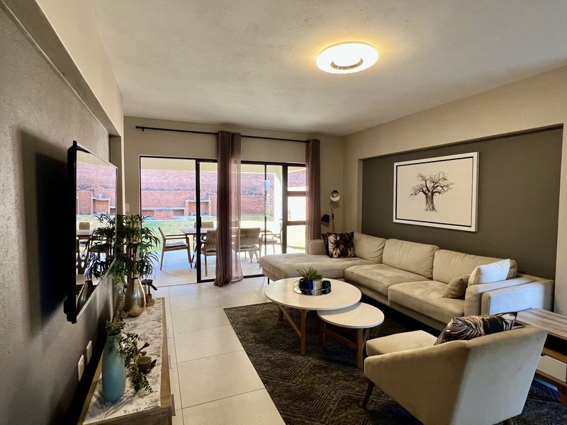 Spacious living room featuring large sliding glass doors that provide seamless access to the outdoor patio area and natural light.