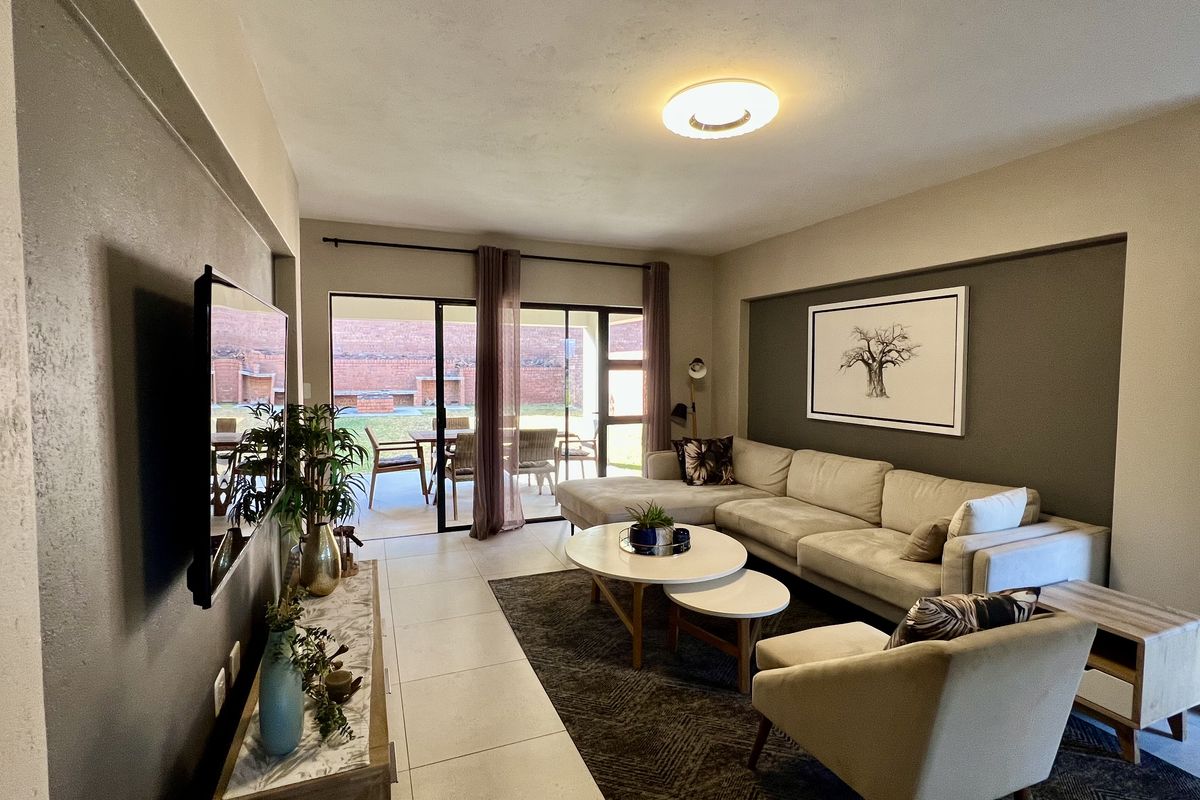 Spacious living room featuring large sliding glass doors that provide seamless access to the outdoor patio area and natural light.