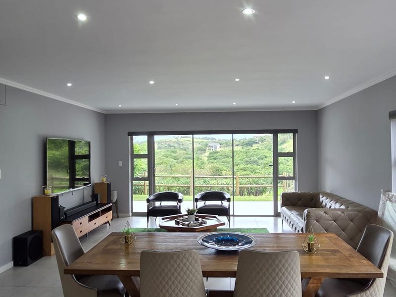 Spacious open-plan living and dining area featuring large sliding glass doors that provide natural light and scenic views.