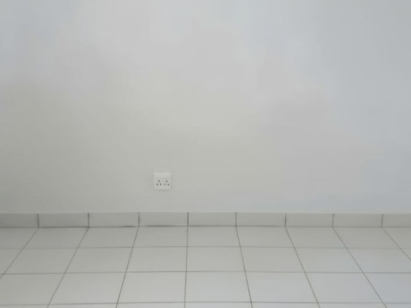 An empty bedroom featuring neutral tiled flooring and white walls, providing a blank canvas for personalization.
