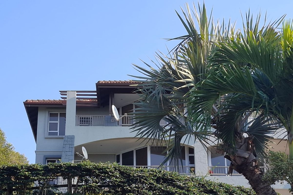 A view of the rear elevation of the apartment building, featuring balconies with railings and a tiled roof structure.
