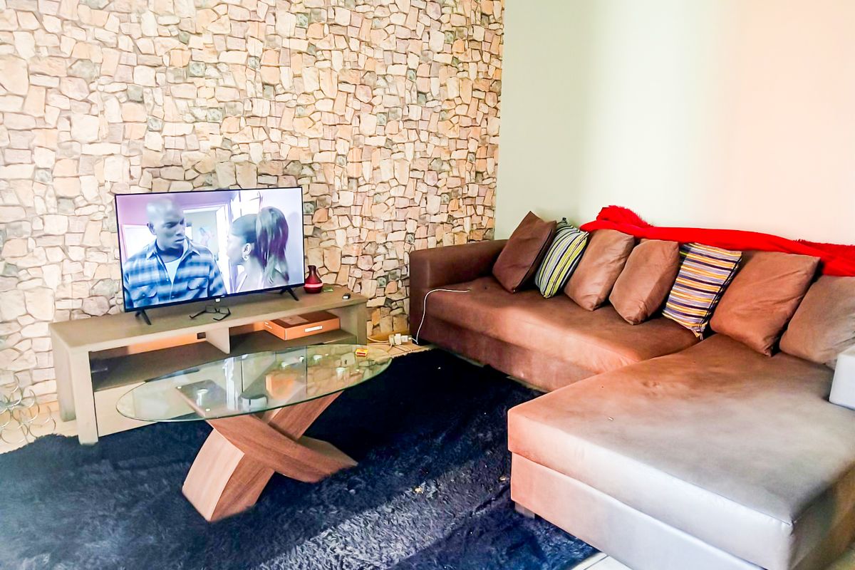A living room featuring a prominent stone veneer accent wall, providing a textured focal point for the space.