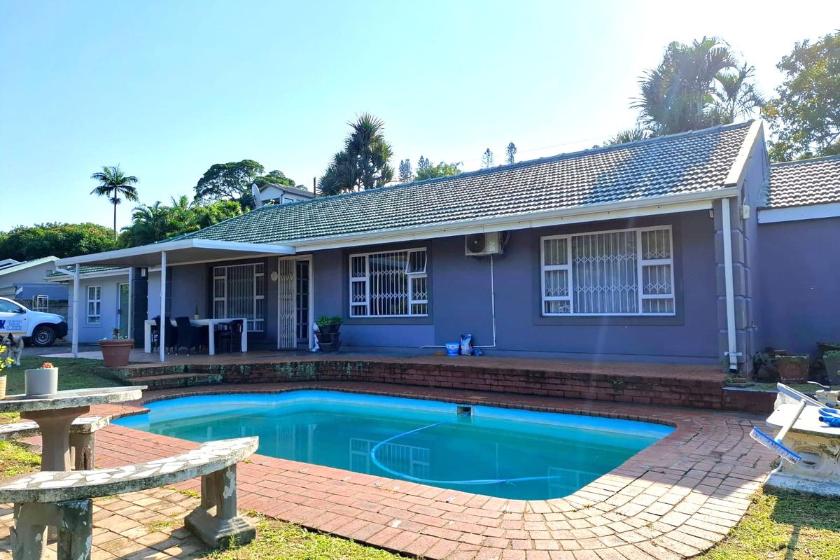 Rear view of the house featuring a swimming pool with brick paving, a covered patio area, and security-fitted windows.