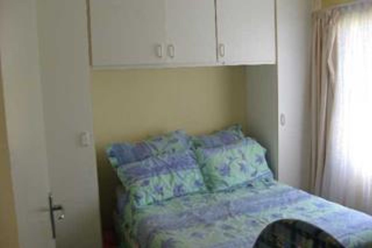 A bedroom featuring built-in cupboards providing overhead storage space.