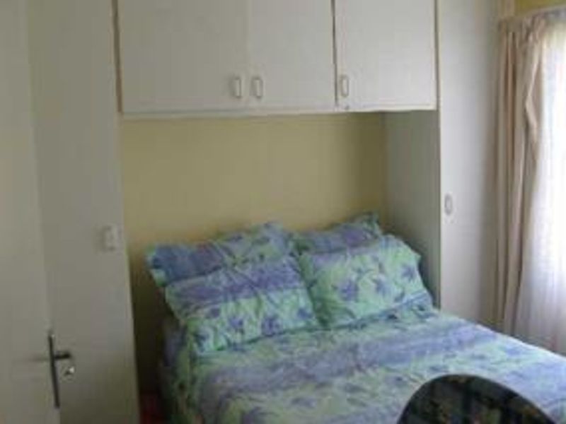 A bedroom featuring built-in cupboards providing overhead storage space.