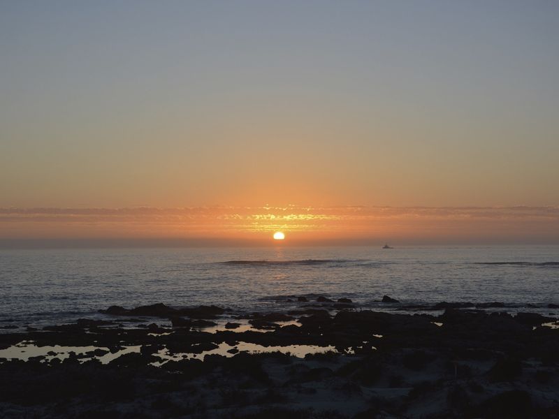 A scenic sunset view over the ocean, showcasing the natural landscape and coastal horizon.