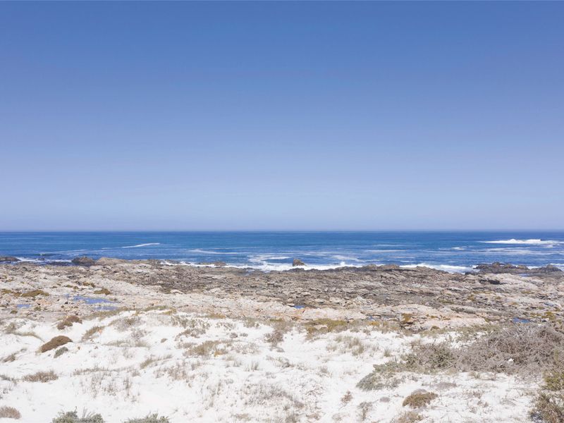 A scenic view of the rocky coastline and ocean, showcasing the natural beauty of the vacant residential land.
