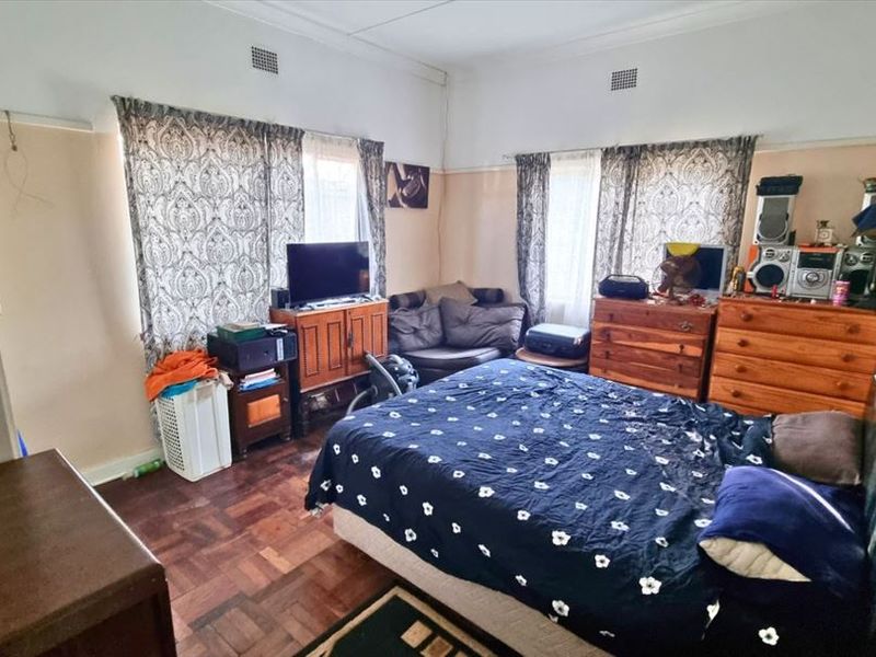 A bedroom featuring classic parquet flooring, decorative picture rails, and traditional cornicing, offering a solid foundation for renovation and modernization.
