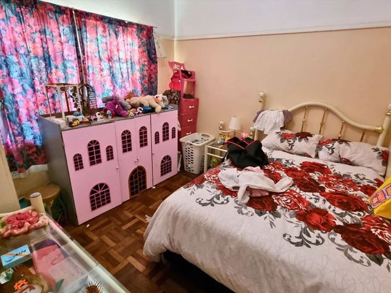 A bedroom featuring classic parquet flooring and a traditional picture rail, offering a functional space ready for a modern update.