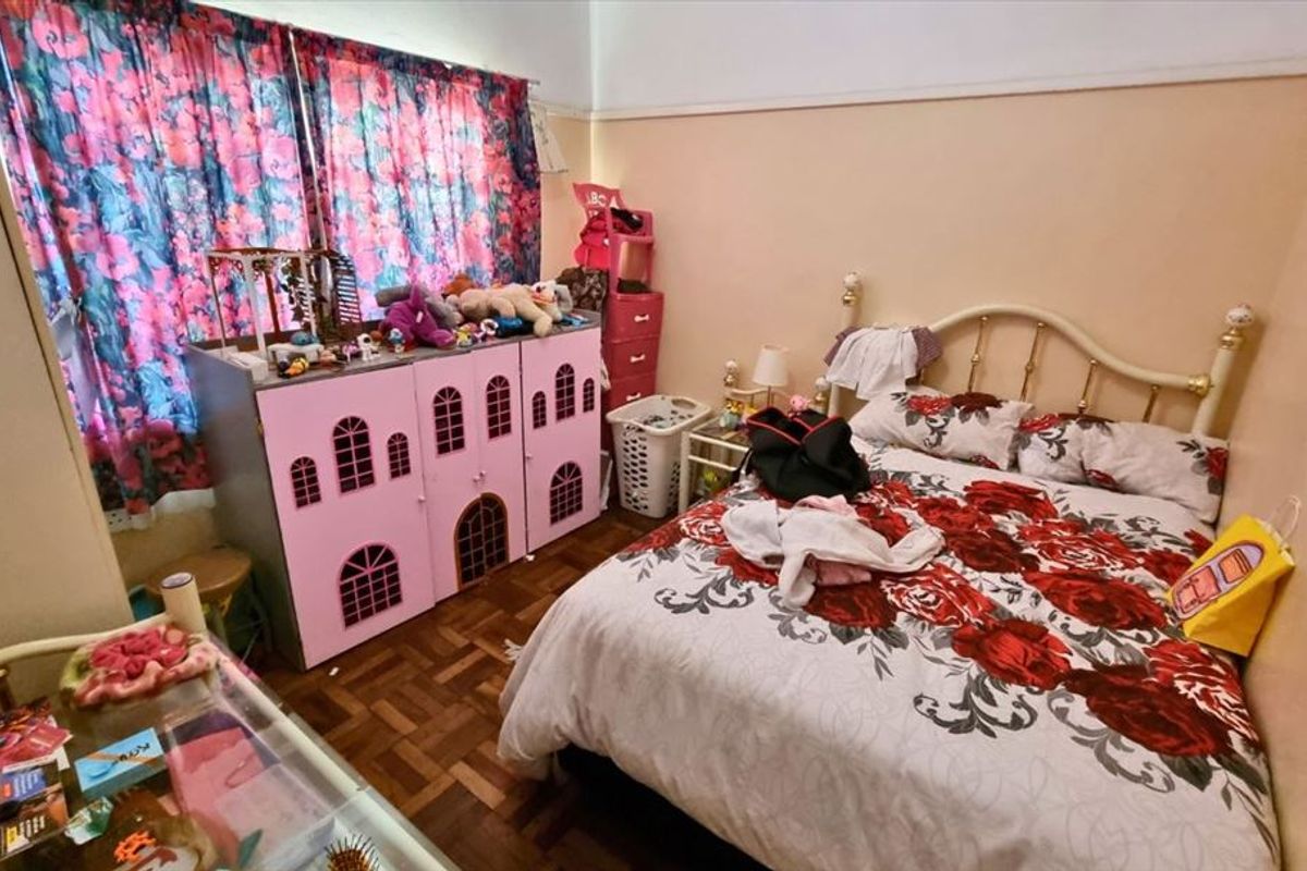 A bedroom featuring classic parquet flooring and a traditional picture rail, offering a functional space ready for a modern update.