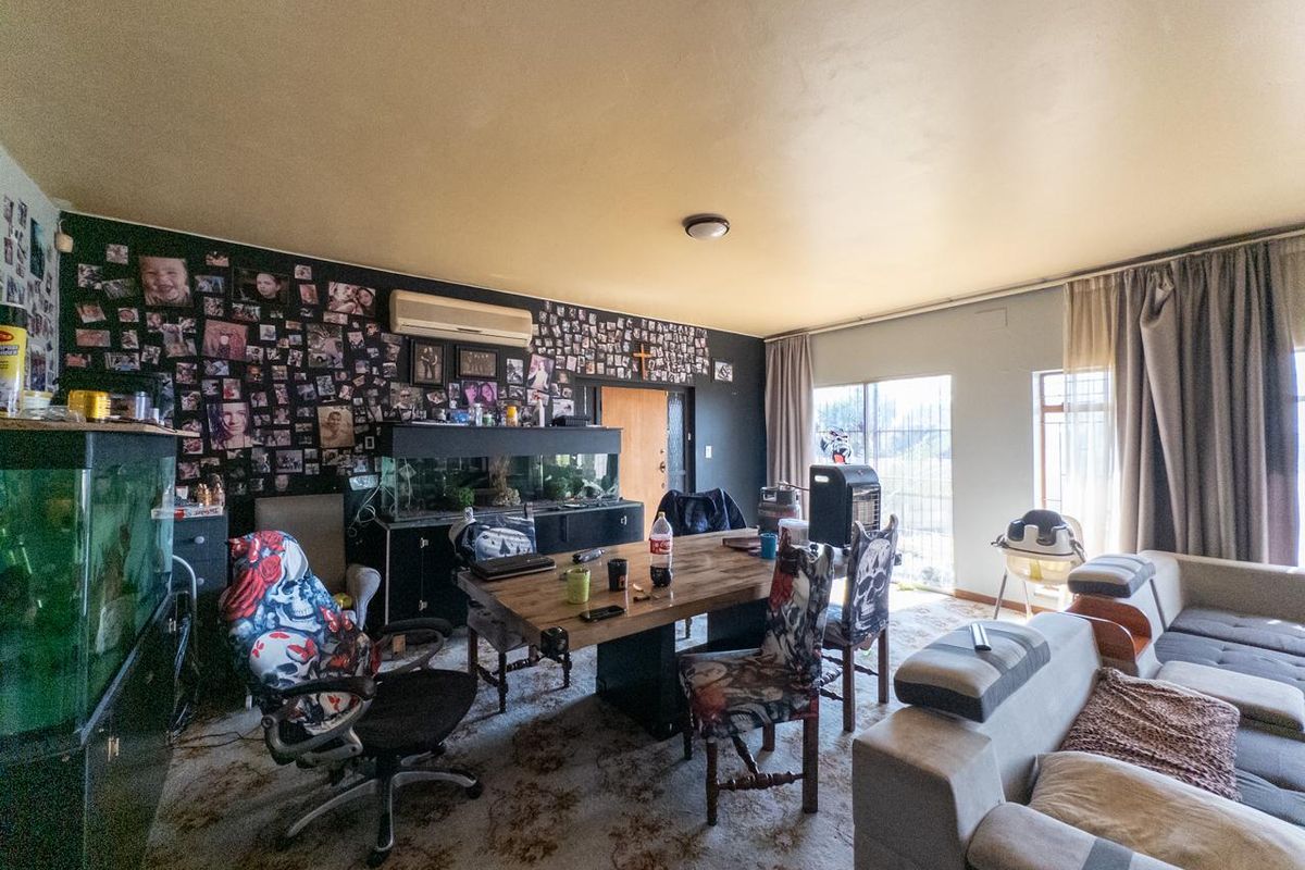 A spacious living area featuring a split-system air conditioner, large windows, and sliding glass door access to the exterior.
