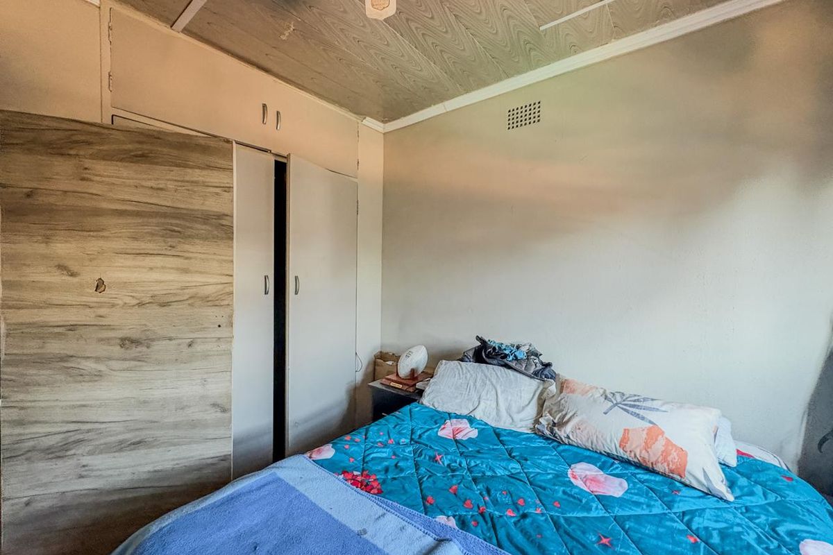 A bedroom featuring built-in cupboards and ceiling panels, requiring cosmetic updates to improve the overall condition and aesthetic appeal.