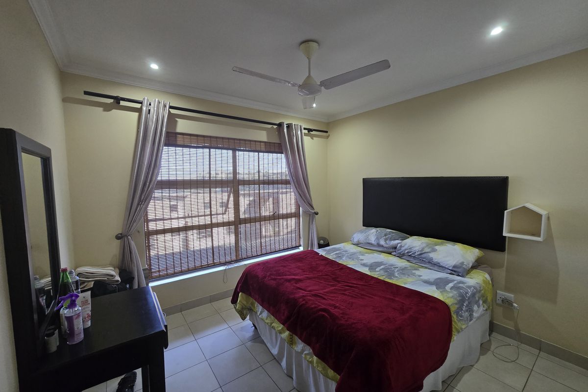 A functional bedroom featuring tiled flooring, a ceiling fan, recessed lighting, and window blinds, providing a comfortable and well-lit living space.