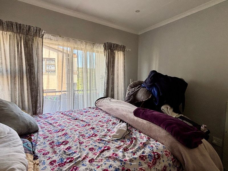 A bedroom featuring a sliding glass door providing access to an outdoor area, complemented by recessed ceiling lighting and coved cornicing.