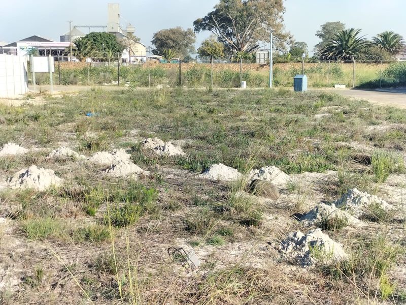 A vacant residential plot featuring perimeter fencing with razor wire, ready for development in a convenient location.