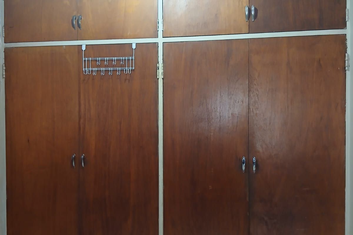 A bedroom featuring floor-to-ceiling built-in wooden cupboards, a wooden ceiling, and tiled flooring.