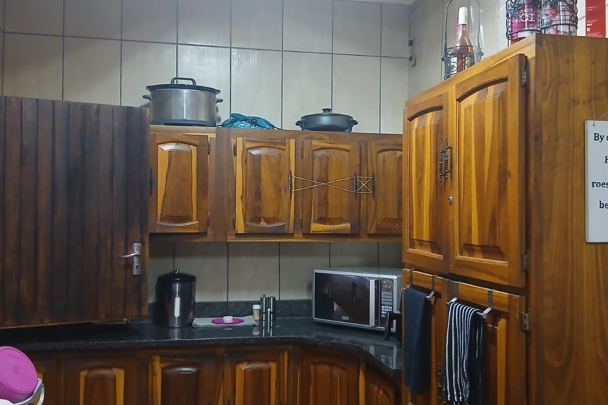 A functional kitchen featuring traditional wooden cabinetry, granite countertops, and tiled finishes, offering a classic layout with ample storage space.