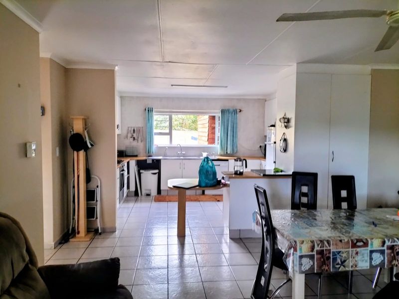 Open plan kitchen and dining area featuring tiled flooring, built-in cabinetry, and a functional layout with direct access to the kitchen workspace.