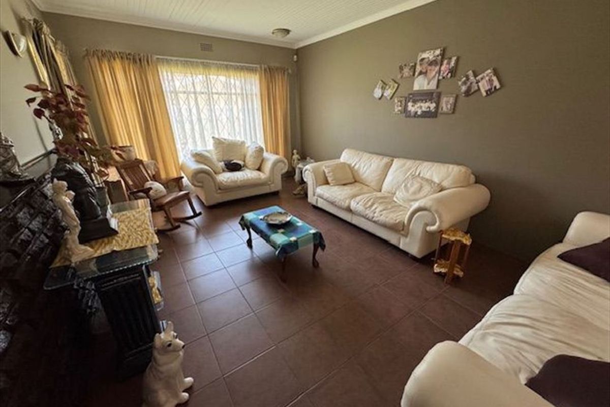 A spacious living room featuring tiled flooring and a beadboard ceiling, providing a comfortable and functional area for relaxation.