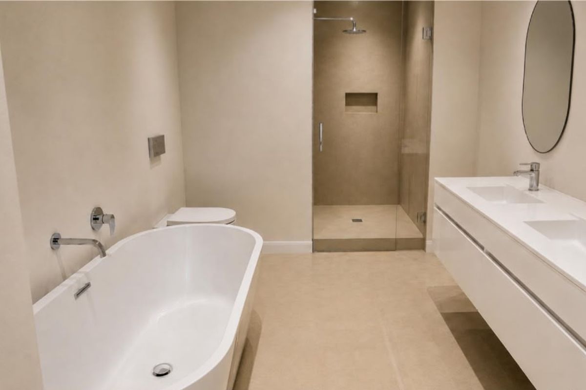 Modern bathroom featuring a double vanity, freestanding bathtub, and a spacious walk-in shower with a recessed niche and glass enclosure.