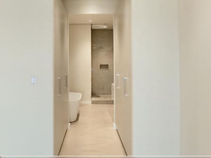 Modern bathroom featuring a freestanding bathtub, walk-in shower with a recessed niche, and ample built-in storage cabinetry.