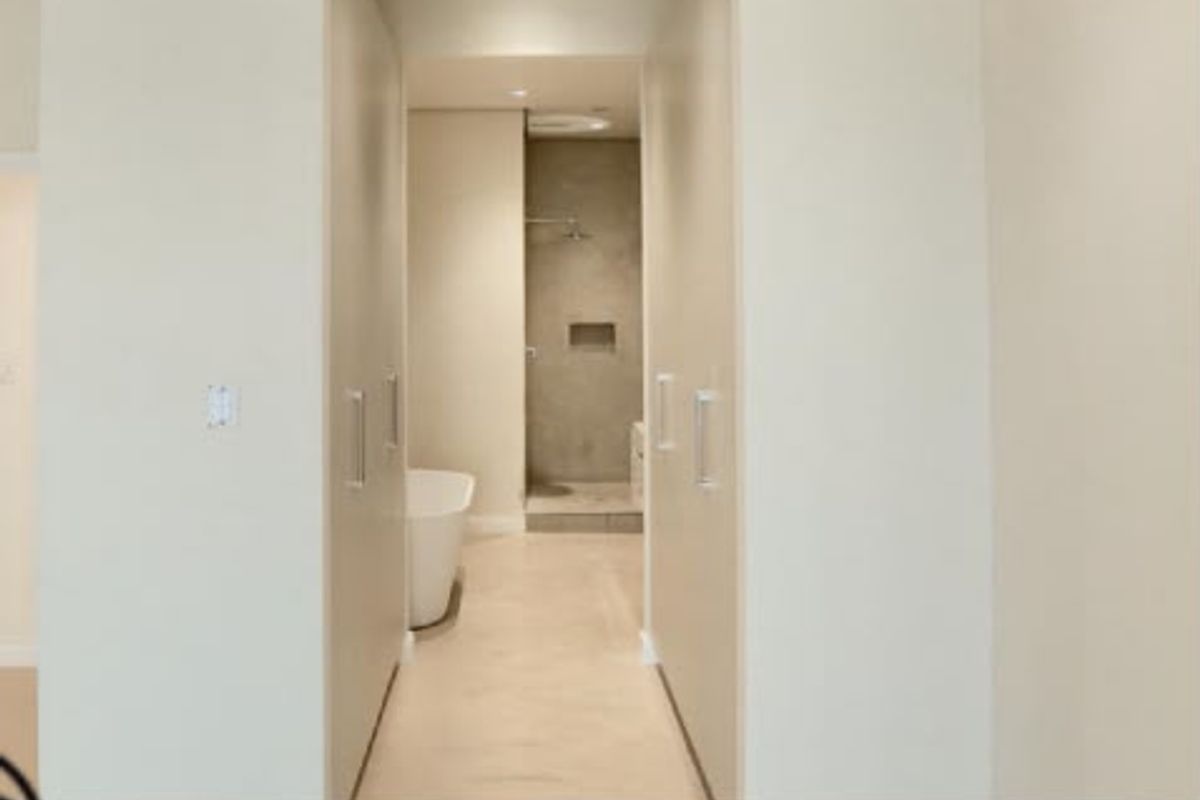 Modern bathroom featuring a freestanding bathtub, walk-in shower with a recessed niche, and ample built-in storage cabinetry.