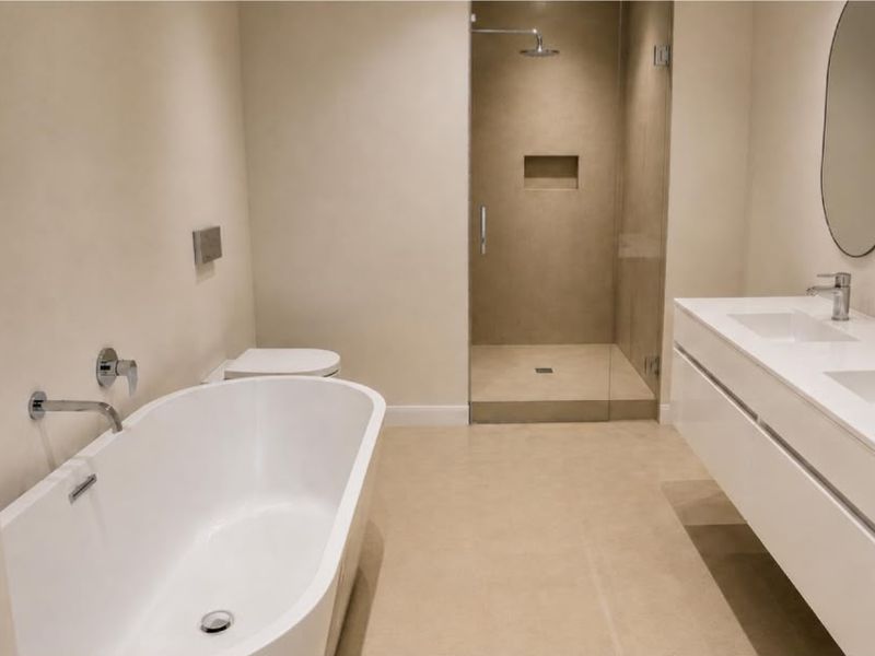 Modern bathroom featuring a double vanity, freestanding bathtub, and a spacious walk-in shower with a recessed niche and glass enclosure.