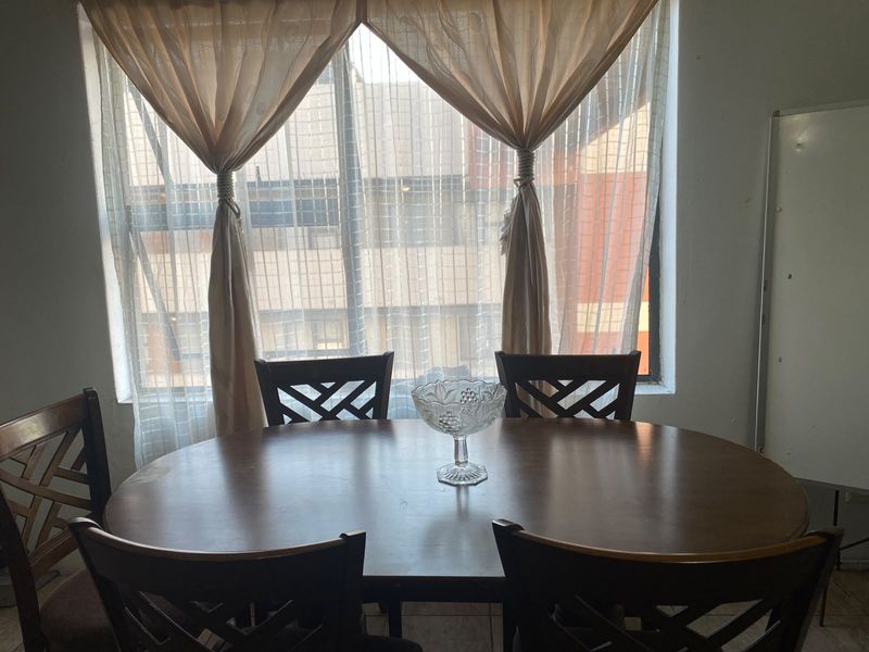 A dining area featuring tiled flooring and a large window providing natural light.