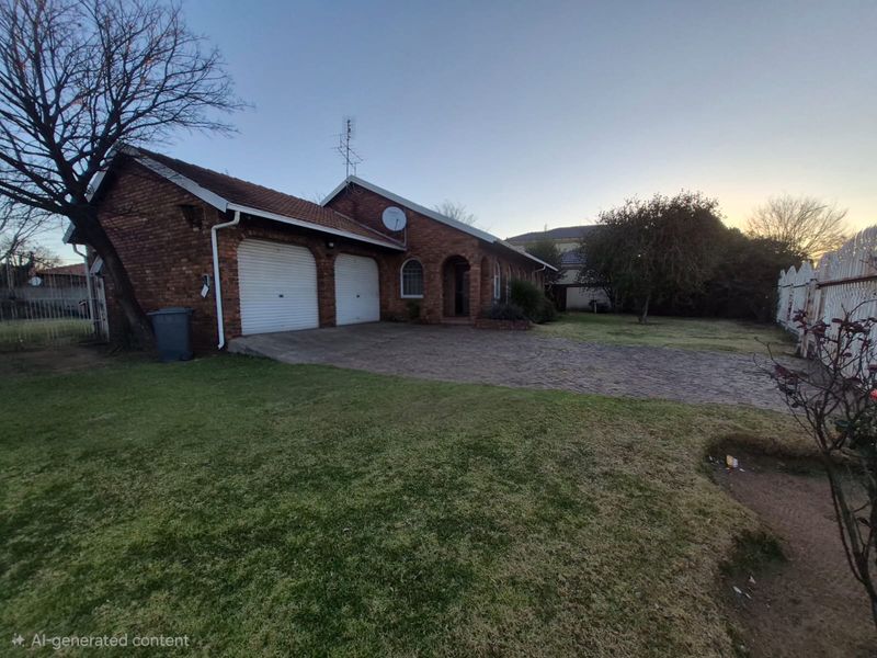 Front exterior view of a single-story brick house featuring a double garage, paved driveway, and established garden area.