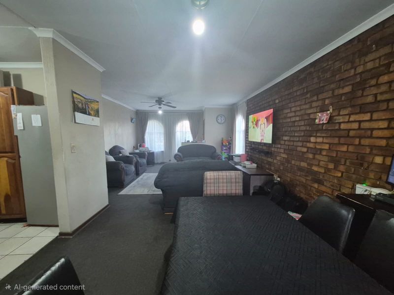 Open plan living and dining area featuring an exposed brick feature wall and ceiling fan, providing a versatile space for family living.