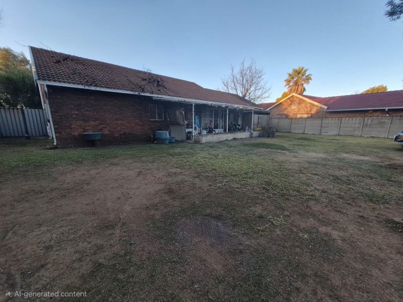 Rear view of the property featuring a brick facade, tiled roof, and a covered patio area overlooking a large, unmaintained garden space.