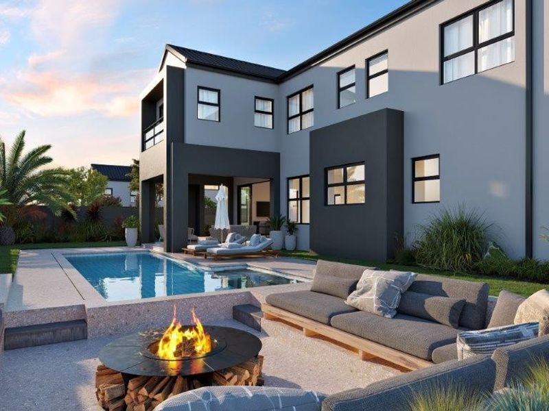 Rear exterior view of a modern cluster home featuring a swimming pool, covered patio, and a sunken fire pit area within a landscaped garden.