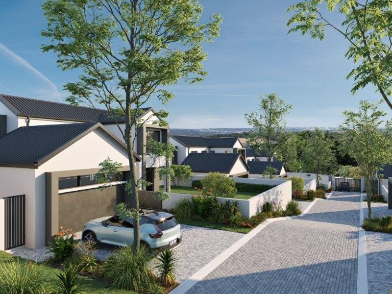 A modern cluster home development featuring paved driveways, pitched roofs, and landscaped boundary walls in a secure estate setting.