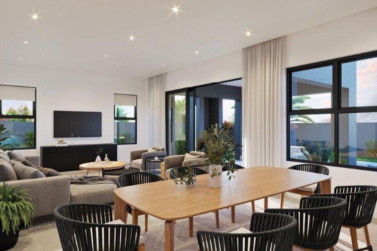 Spacious open-plan living and dining area featuring large sliding glass doors that provide seamless access to the outdoor patio and garden.