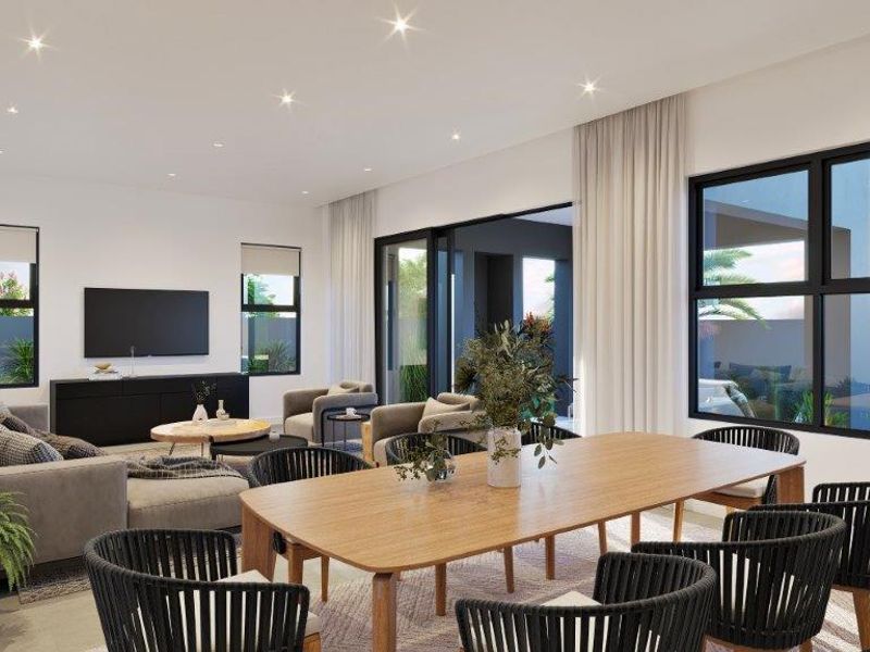 Spacious open-plan living and dining area featuring large sliding glass doors that provide seamless access to the outdoor patio and garden.