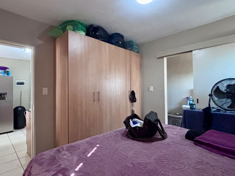 Bedroom featuring a large built-in wooden wardrobe and access to an adjoining bathroom area.