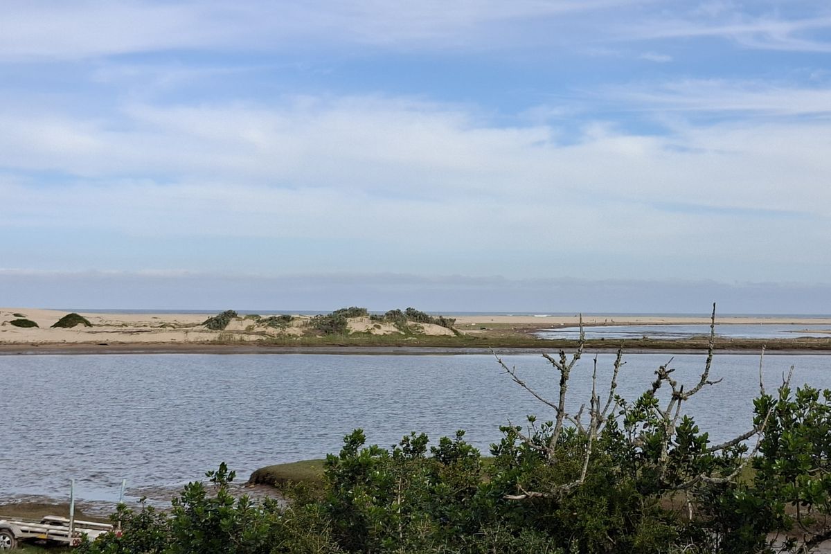 A scenic view of the estuary and sand dunes, showcasing the natural coastal landscape of the property.