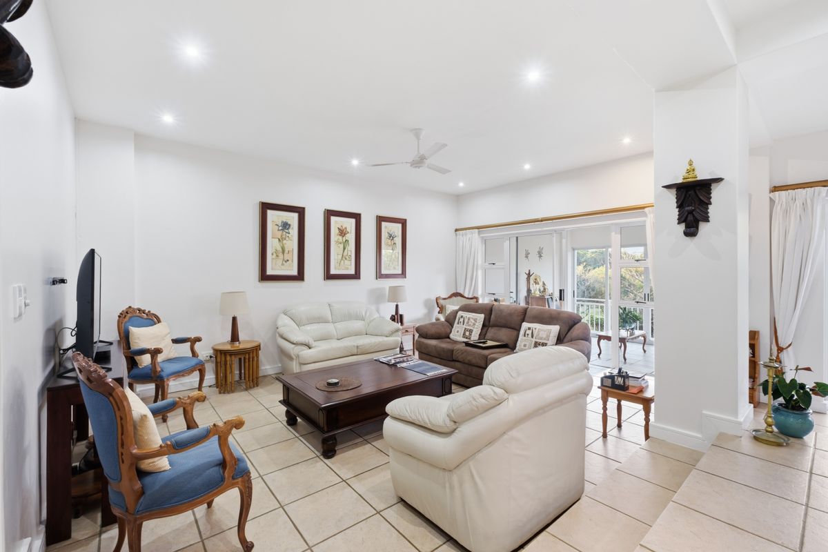 Spacious living room featuring tiled flooring, recessed downlighting, and large sliding glass doors providing access to the outdoor area.