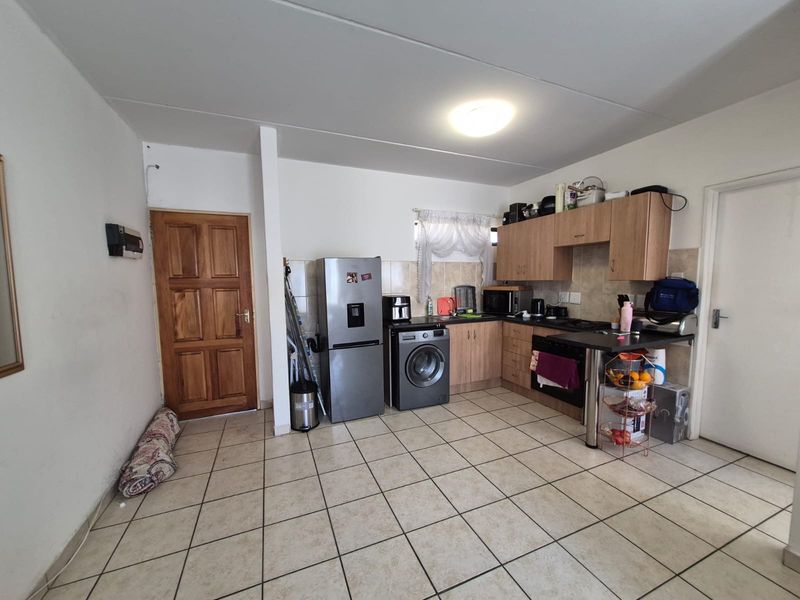 Functional kitchen featuring tiled flooring, built-in cabinetry, a breakfast counter, and integrated cooking appliances.