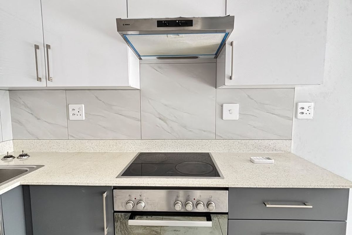 Modern kitchen featuring two-tone cabinetry, stone countertops, marble-look splashback, and integrated Bosch oven and hob.
