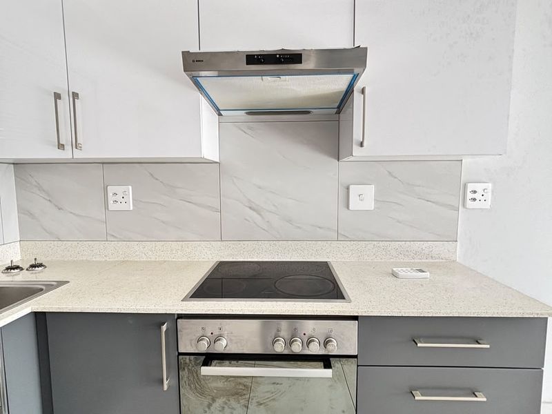 Modern kitchen featuring two-tone cabinetry, stone countertops, marble-look splashback, and integrated Bosch oven and hob.