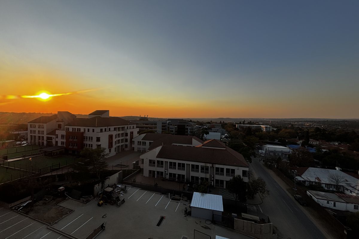 An elevated aerial view of the surrounding neighborhood and commercial buildings during a sunset.