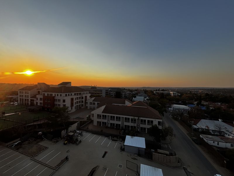 An elevated aerial view of the surrounding neighborhood and commercial buildings during a sunset.