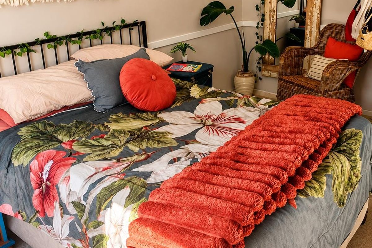 A cozy bedroom featuring neutral wall tones, a decorative chair rail, and carpeted flooring.