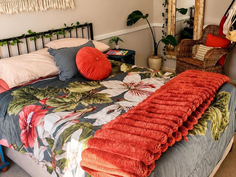 A cozy bedroom featuring neutral wall tones, a decorative chair rail, and carpeted flooring.