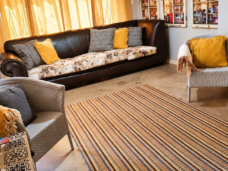 A living room featuring polished concrete floors and large windows with curtain treatments, offering a neutral base for interior design updates.